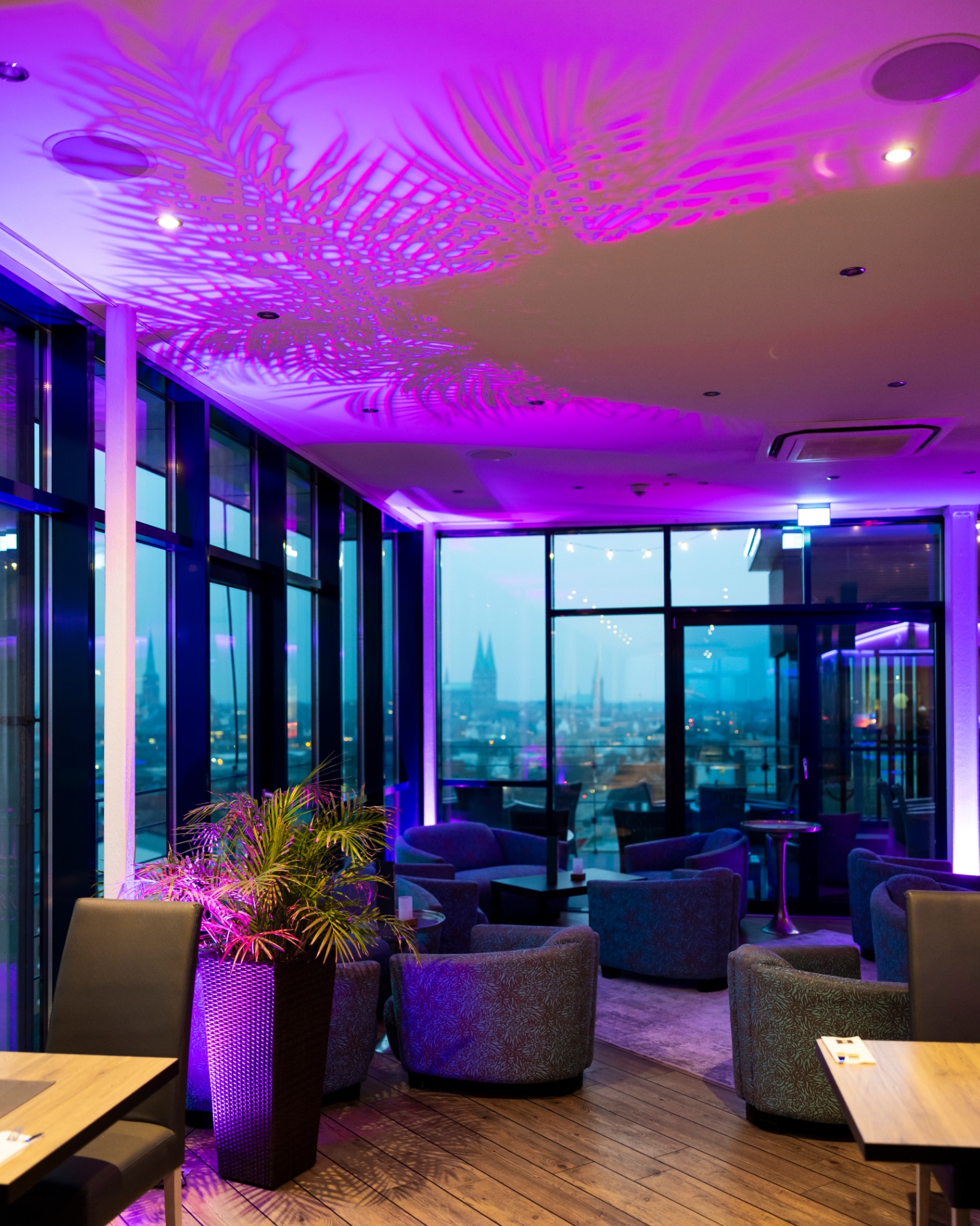 Modern lounge area with purple ambient lighting and panoramic views